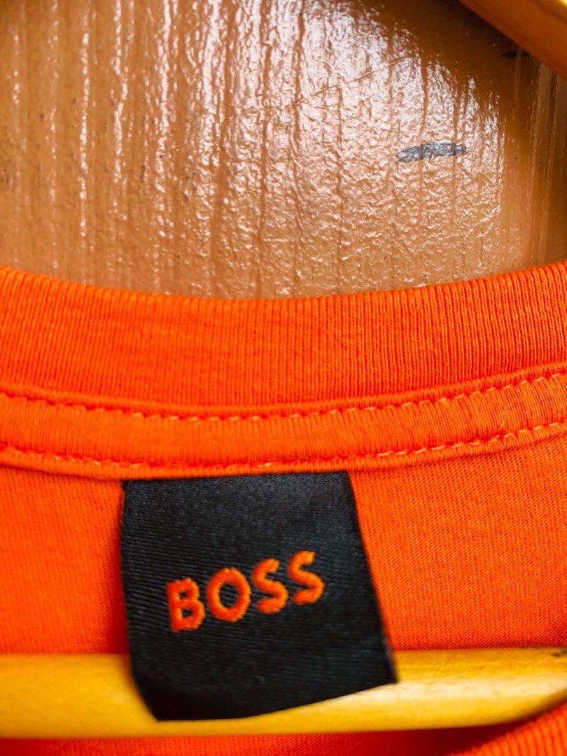 BOSS Orange T-Shirt Size M (Category: Tshirts & Polo Shirts ) located in Digos. Submitted by thrifthed.ph (Listing ID 1462666223, Image 3). Description: - Orange BOSS t-shirt -med -like new -cl:10/10 -authentic -dimes:20/28 -no issue -solid condi -solid colorate -authentic -suitable for picky buyer - - Features circular BOSS logo graphic on the back - Smaller BOSS logo on the chest - Made from comfortable material - Ideal for casual wear - Please