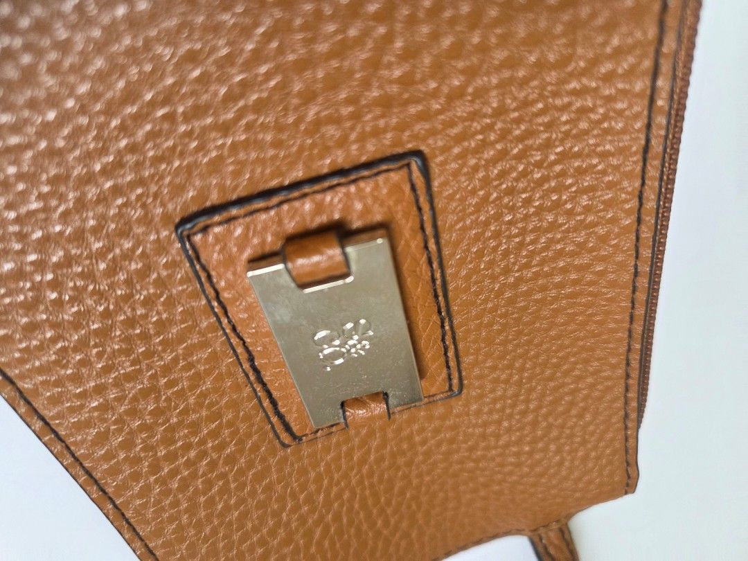 Brown Leather Card Holder with Strap and Zipper (Category: Wallets & Card holders) located in Bacolod City. Submitted by maraline (Listing ID 1462460668, Image 3). Description: • Brand: 100% Authentic XOXO • Color/Material: Cognac Brown / Caramel with a subtle metallic glitter texture. Saffiano or pebbled-style faux/vegan leather • Hardware: Silver-tone metal logo plate and smooth zipper closure • Size: Compact & lightweight (Approx. 6.5" x 4") —