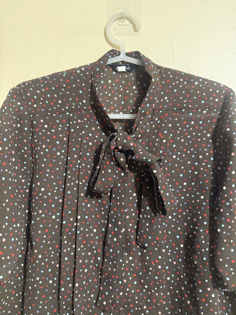 Brown Polka Dot Blouse with Tie Neck (Category: Blouses) located in Quezon City. Submitted by lau_v (Listing ID 1462539615, Image 2). Description: - Brown blouse with a vibrant, colorful polka dot print. - Elegant tie neck detail. - Flattering pleats down the front. - Comfortable short sleeves. - Fits M-L. - length: 20" -widtg: 21" - Easily pairs with skirts or pants..