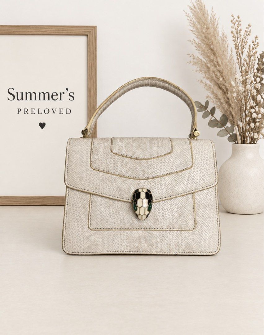 Bulagari Serpenti handle bag (Category: Tote Bags) located in Taguig. Submitted by summers.preloved (Listing ID 1462607170, Image 1). Description: 👜 Bag Details 🤍 Ivory snakeskin-effect textured exterior 🐍 Iconic enamel Serpenti head closure with green eye details 💜 Gold-tone hardware 👜 Structured single top handle 🔒 Secure push-lock flap closure 📂 Expandable accordion-style construction 🖤 Three spacious black-lined compartments 🏷️ Inter