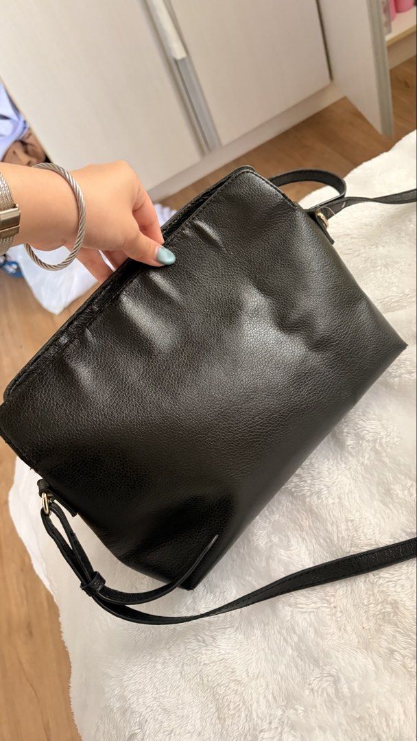 Burberry Black Leather Crossbody Bag (Category: Luxury Bags & Wallets) located in Caloocan City. Submitted by riahnicole98224 (Listing ID 1462445037, Image 3). Description: Burberry Leah - Burberry black leather crossbody bag - Features classic Nova Check lining - Secure zipper closure for the main compartment - Adjustable strap for comfortable wear - Shows some signs of wear on the leather, adding character.