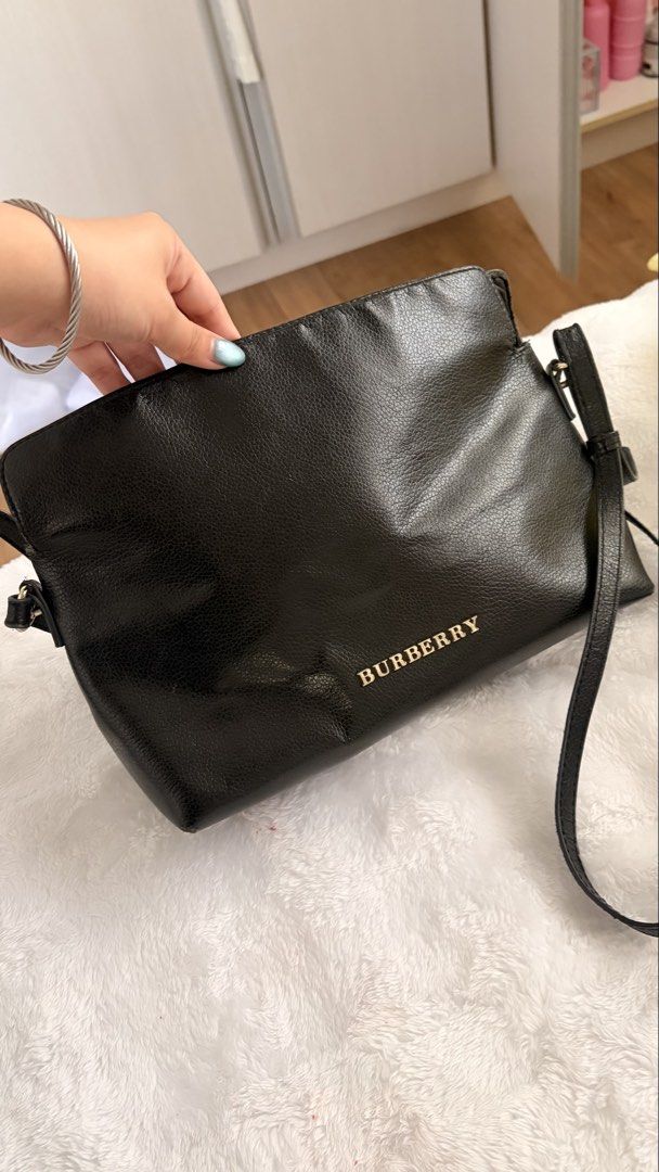 Burberry Black Leather Crossbody Bag (Category: Luxury Bags & Wallets) located in Caloocan City. Submitted by riahnicole98224 (Listing ID 1462445037, Image 2). Description: Burberry Leah - Burberry black leather crossbody bag - Features classic Nova Check lining - Secure zipper closure for the main compartment - Adjustable strap for comfortable wear - Shows some signs of wear on the leather, adding character.