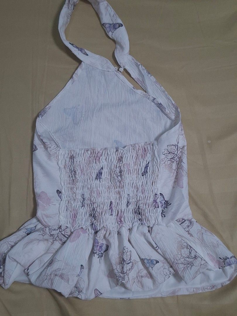 Butterfly Floral Smocked Halter Top (Category: Sleeveless) located in Manila. Submitted by preloved_tweeds_ph (Listing ID 1462615820, Image 3). Description: small to medium loc: pampanga - White halter top - Pretty butterfly and floral print - Smocked back for a comfortable fit - Straps tie at the neck - Textured fabric - Ideal for casual outings or beach trips.