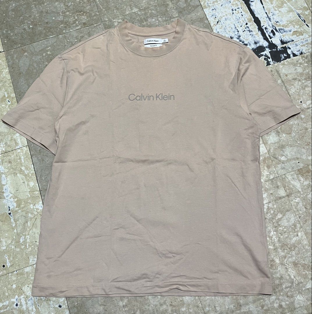 Calvin Klein Beige T-shirt (Category: Tshirts & Polo Shirts ) located in Manila. Submitted by jlogup08 (Listing ID 1462628393, Image 1). Description: - Classic beige Calvin Klein t-shirt - Features a small, understated logo on the chest - Made for comfort and casual everyday wear - Versatile and easy to pair with any outfit.
