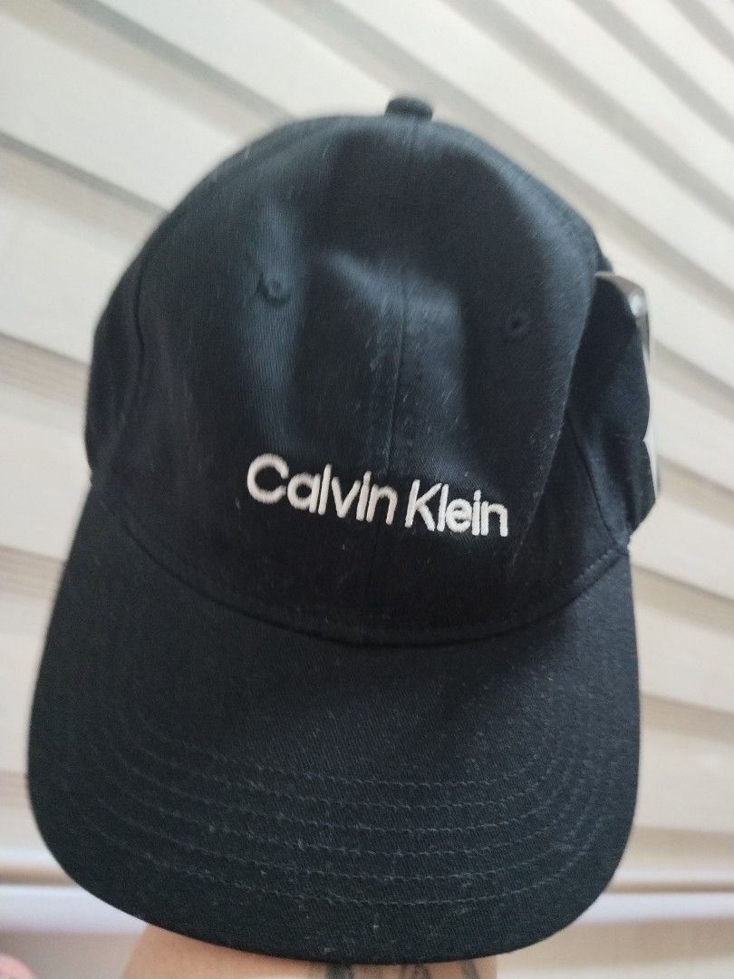 Calvin Klein Black Baseball Cap (Category: Caps & Hats) located in Abulug. Submitted by liezlmbern66192 (Listing ID 1462603613, Image 2). Description: - Classic black Calvin Klein cap - Features embroidered Calvin Klein logo on the front - Adjustable strap at the back for a customized fit - Perfect for everyday wear - Authentic item, purchased from TJ Maxx.