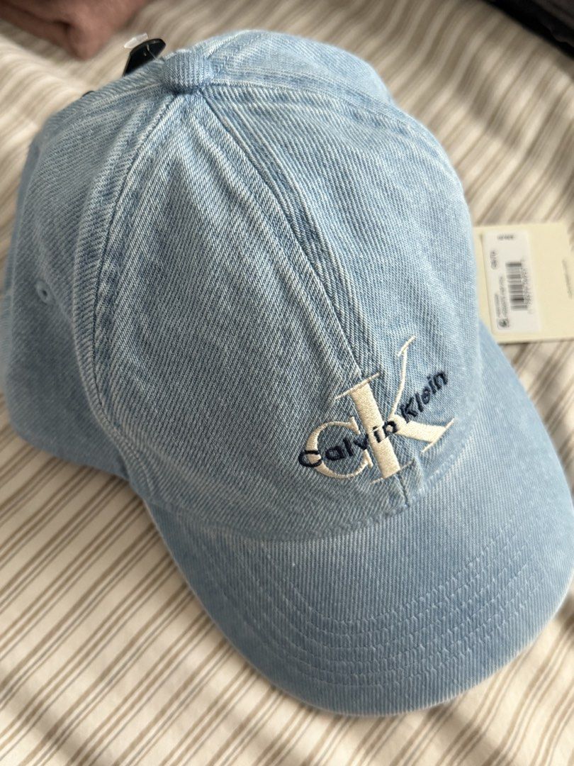 Calvin Klein Denim Baseball Cap (Category: Caps & Hats) located in Angeles City. Submitted by chubbyneko (Listing ID 1462486864, Image 2). Description: - Brand: Calvin Klein - Style: Light wash denim cap - Features: Embroidered classic CK logo on front - Fit: Adjustable strap with metal buckle at the back - Condition: Brand new with tags - Perfect for: Casual wear.