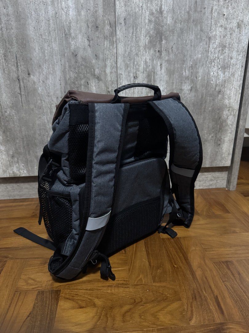 Camera Backpack!! (Category: Backpacks) located in Singapore. Submitted by aniqkelodeon (Listing ID 1462551967, Image 2). Description: - Dark grey fabric body with brown faux leather flap - Main compartment secured by drawstring closure - Zippered pocket on the flap for extra security - Padded shoulder straps for comfortable carrying - Convenient side mesh pockets - Internal dividers, suitable for organizing camera equipment.