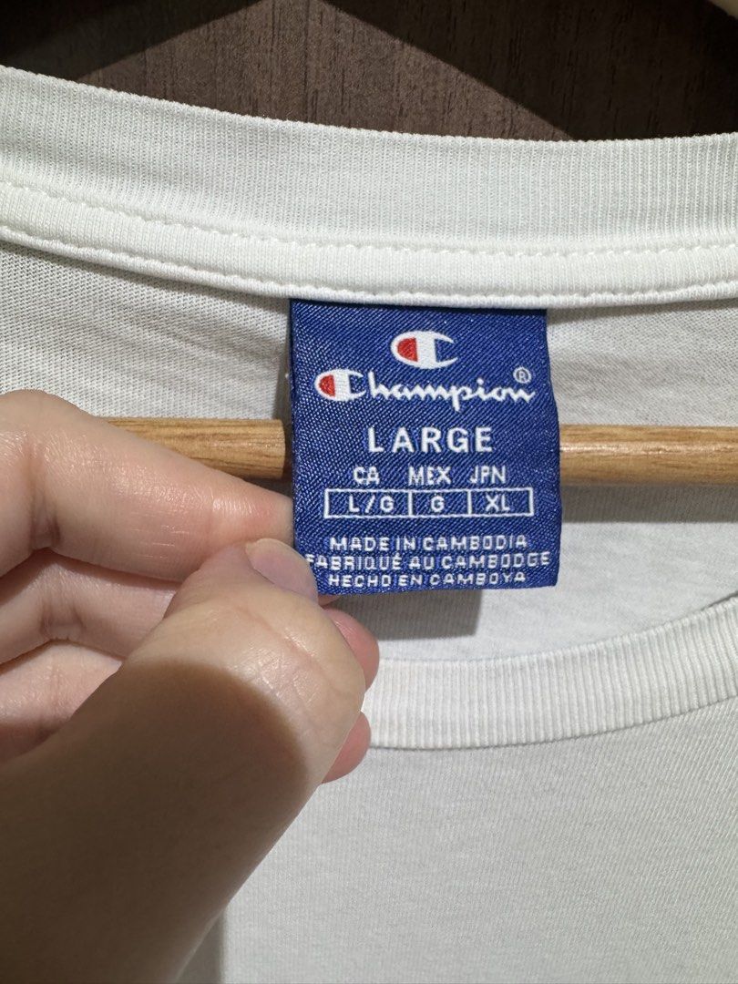 Champion white tshirt (Category: Shirts) located in Valenzuela. Submitted by shop.spark.joy (Listing ID 1462666012, Image 2). Description: L-27 in W-21 in.
