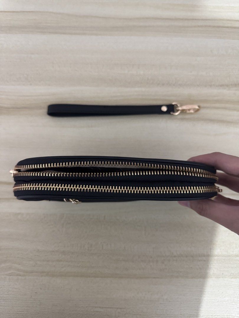 CLN Black Pouch with Wrist Strap (Category: Purses & Pouches) located in Iligan City. Submitted by yzandrayvo70150 (Listing ID 1462643172, Image 3). Description: - Stylish black pouch with a gold zipper. - Features a separate zippered compartment for extra organization. - Comes with a convenient detachable wrist strap. - Ideal for keeping your essentials tidy. - Compact design fits easily into larger bags..