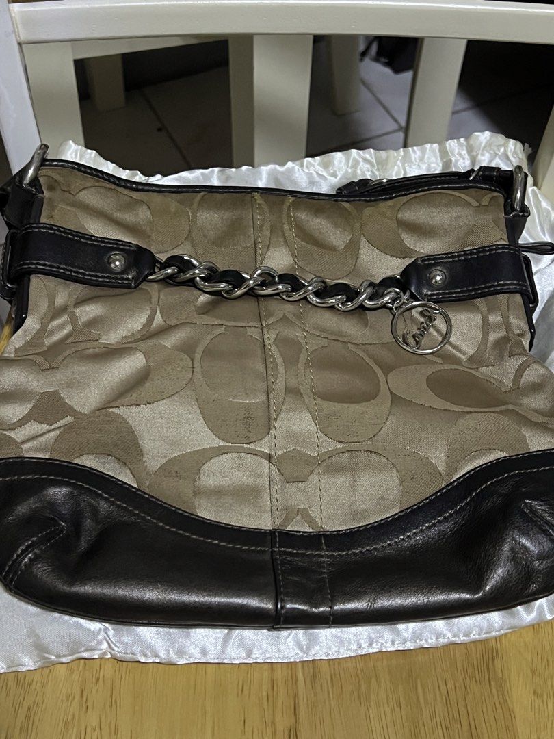 Coach Monogram Canvas Leather Trim Shoulder Bag (Category: Luxury Bags & Wallets) located in Taguig. Submitted by paulll_845 (Listing ID 1462553307, Image 3). Description: - Classic Coach shoulder bag - Beige and brown monogram canvas with black leather trim - Decorative chain detail at the front - Interior zippered pocket and slip pockets - Made in the Philippines - Serial number: E1221-F19730 Price: ₱2,500 .