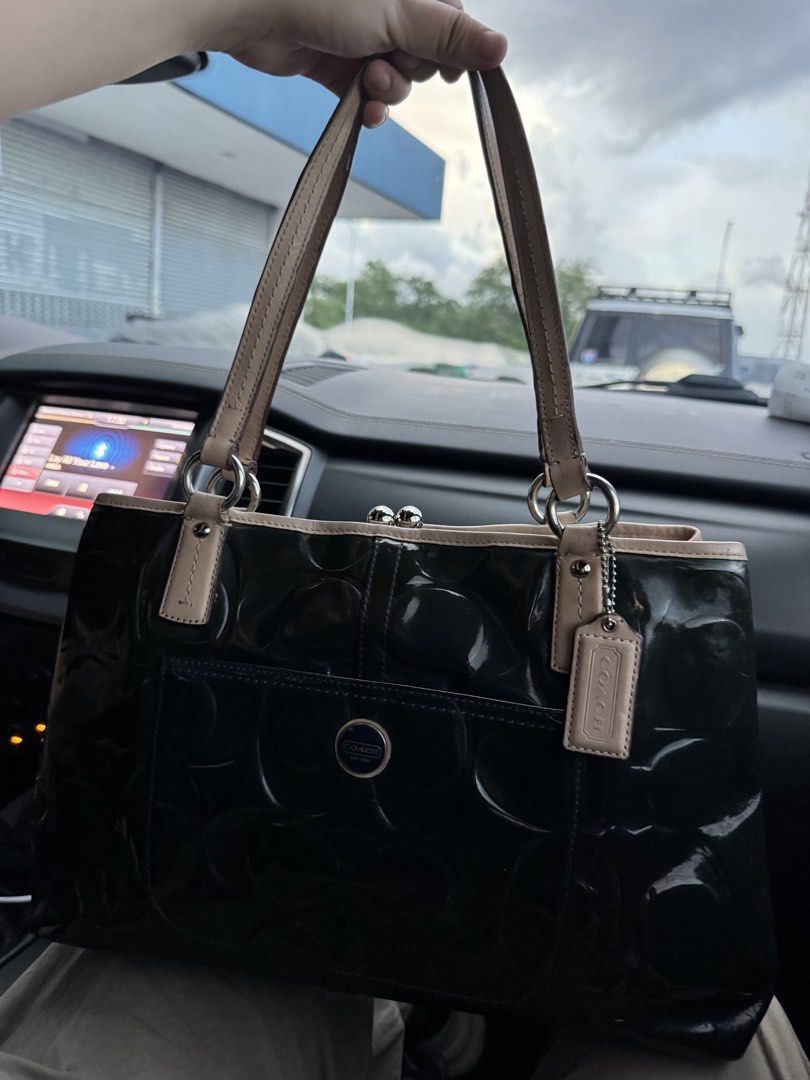 Coach Patent Leather Embossed Tote Bag (Category: Luxury Bags & Wallets) located in Cabanatuan. Submitted by dgbordador (Listing ID 1462576227, Image 1). Description: - Genuine black patent leather Coach tote bag - Elegant embossed pattern - Contrasting beige trim and handles - Convenient back zipper pocket - Interior features multiple compartments and a secure clasp closure - Serial number C138-523487 visible - Ideal for everyday use.