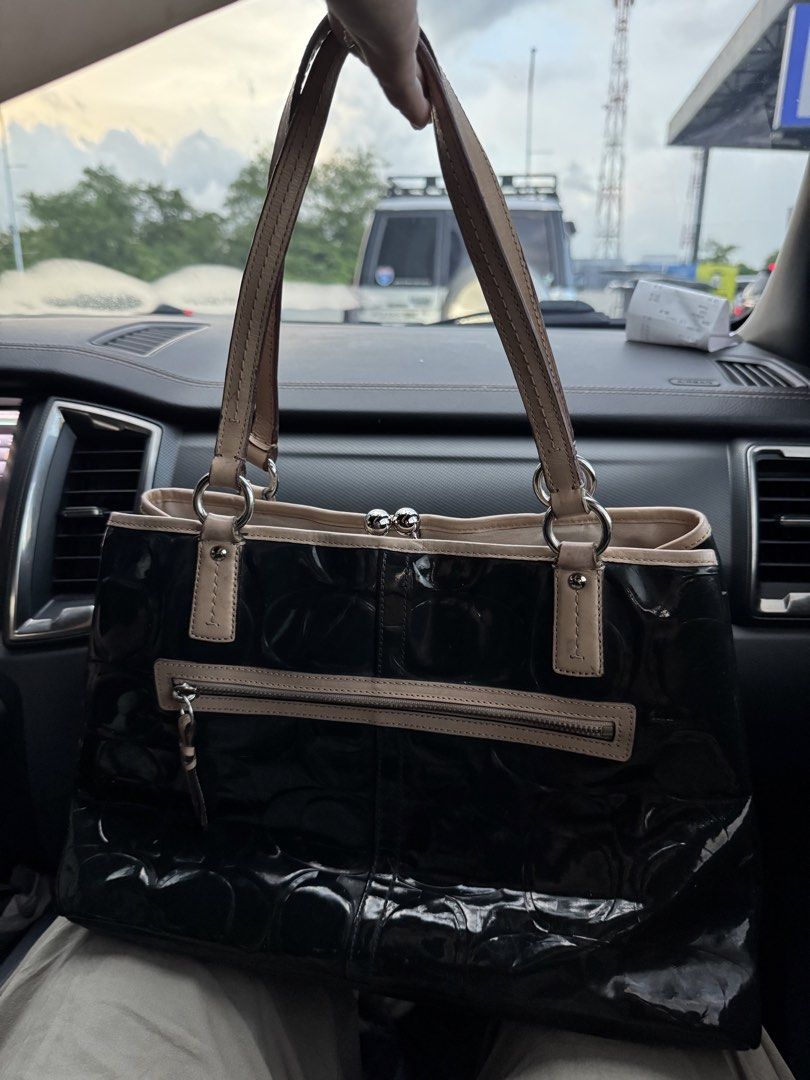 Coach Patent Leather Embossed Tote Bag (Category: Luxury Bags & Wallets) located in Cabanatuan. Submitted by dgbordador (Listing ID 1462576227, Image 2). Description: - Genuine black patent leather Coach tote bag - Elegant embossed pattern - Contrasting beige trim and handles - Convenient back zipper pocket - Interior features multiple compartments and a secure clasp closure - Serial number C138-523487 visible - Ideal for everyday use.