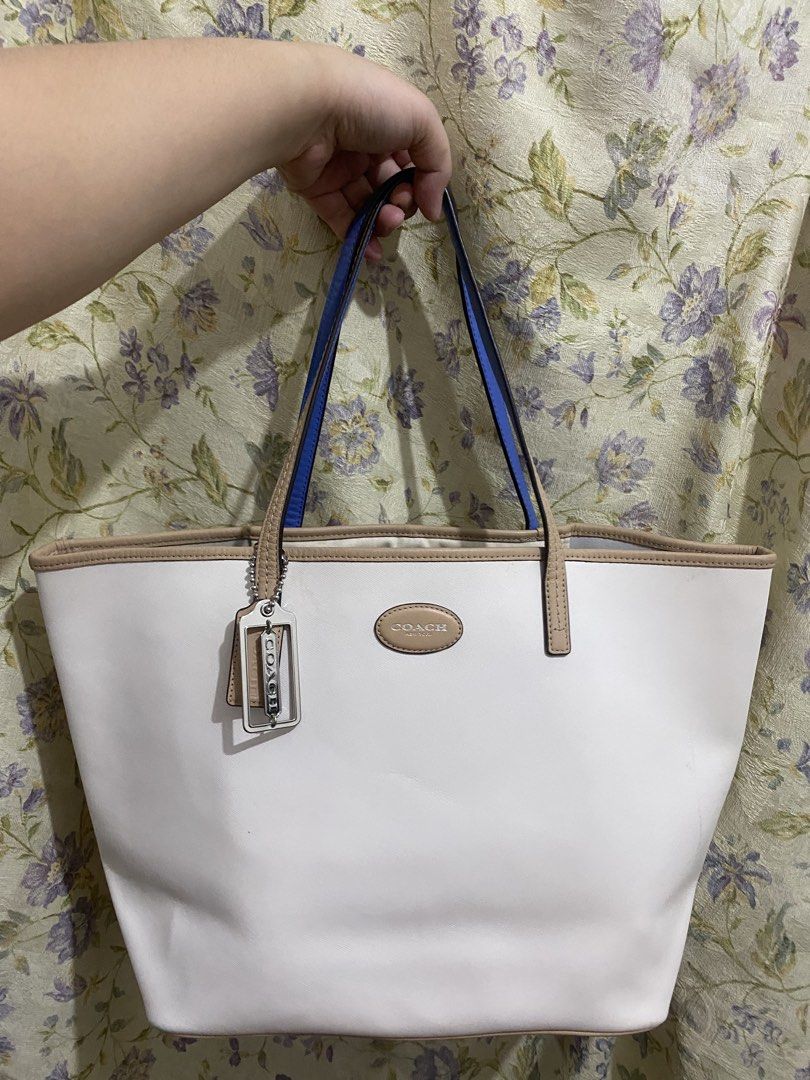 Coach White Leather Tote Bag (Category: Luxury Bags & Wallets) located in Binan City. Submitted by prelovedlagunaph (Listing ID 1462620715, Image 1). Description: - Authentic Coach white leather tote bag - Stylish tan trim and blue strap accents - Large interior with multiple pockets for organization - Comes with original Coach leather tag - Ideal for everyday use and errands.