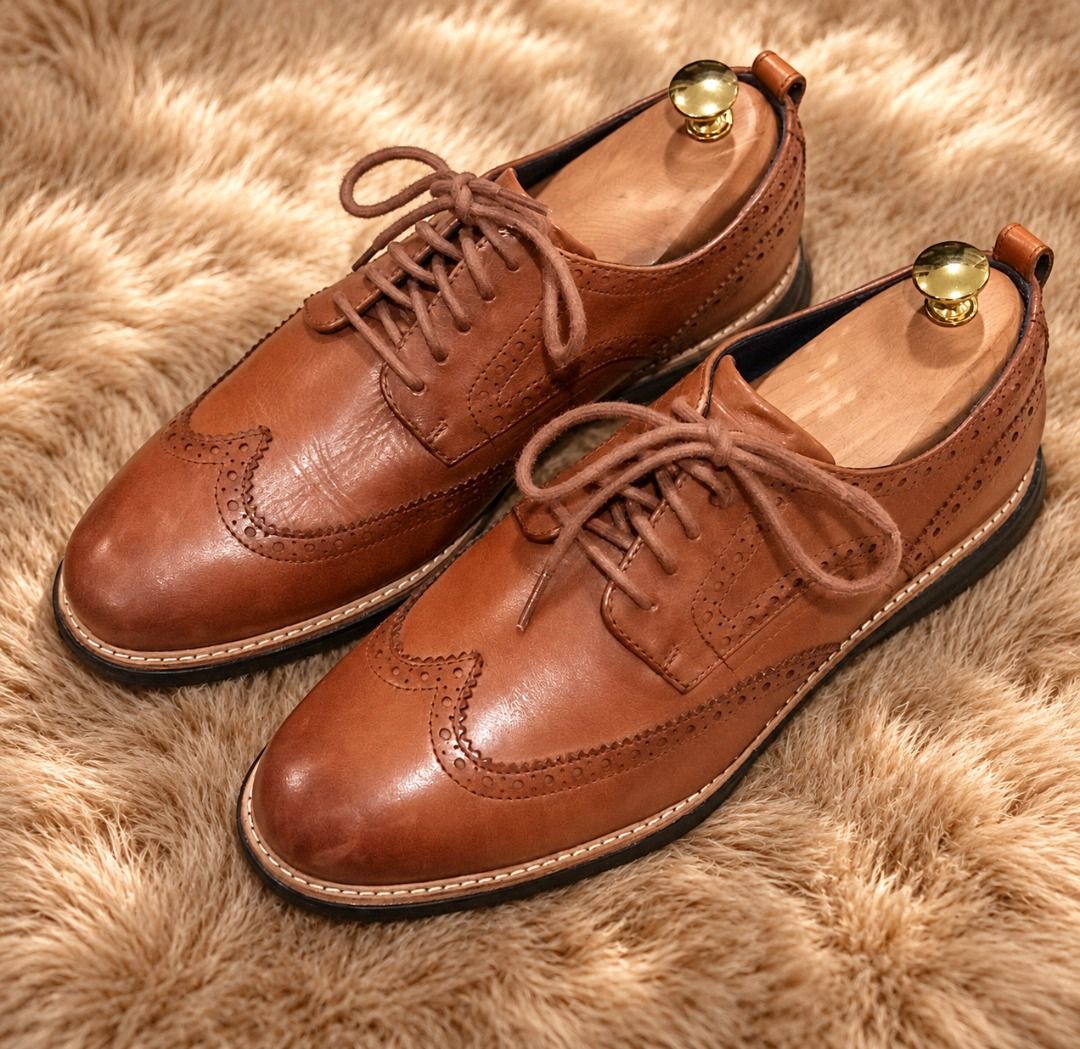 Cole Haan Grand Evolution Wingtip Oxford in British Tan Java (Category: Dress Shoes) located in Paranaque City. Submitted by sole2squeeze (Listing ID 1462440982, Image 1). Description: - Classic brown leather wingtip brogues - Timeless design with intricate broguing - Excludes wooden shoe trees - Versatile for smart casual or formal occasions - Size 10 1/2 W.