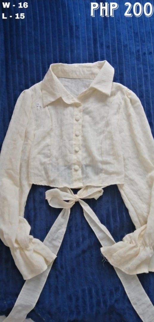 Cream Cropped Blouse with Bow Detail (Category: Blouses) located in Batangas. Submitted by zenshark-e5f6 (Listing ID 1462445865, Image 1). Description: - Cream cropped blouse - Long sleeves with ruffled cuffs - Collared neckline - Button-up front - Adorable bow detail at the waist - Measurements: W-16, L-15.