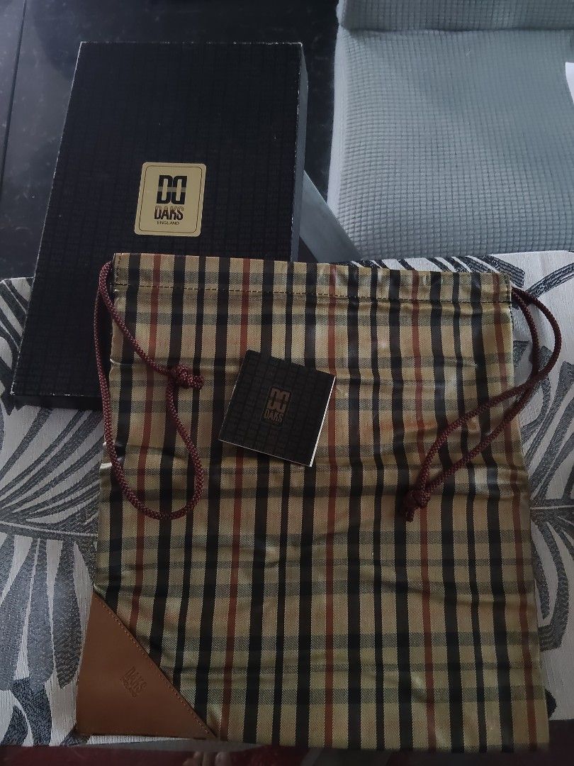 DAKS England Plaid Drawstring Pouch Bag with Box (Category: Purses & Pouches) located in Batangas. Submitted by ms.d_preloveditems (Listing ID 1462479449, Image 1). Description: - Authentic DAKS England plaid pouch - Features a classic drawstring closure - Elegant leather trim accents - Comes with original box and tag - Ideal for organizing essentials or as a travel companion - Lined interior in black - Offers a charming vintage aesthetic.
