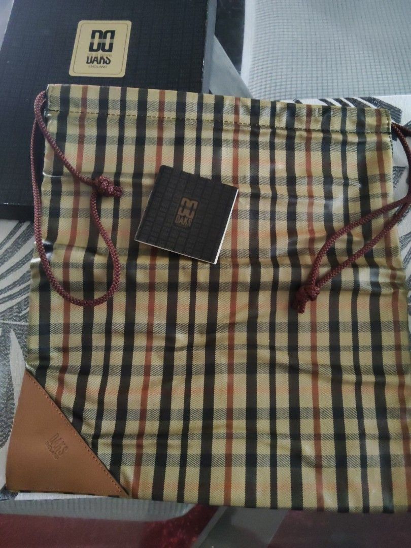 DAKS England Plaid Drawstring Pouch Bag with Box (Category: Purses & Pouches) located in Batangas. Submitted by ms.d_preloveditems (Listing ID 1462479449, Image 2). Description: - Authentic DAKS England plaid pouch - Features a classic drawstring closure - Elegant leather trim accents - Comes with original box and tag - Ideal for organizing essentials or as a travel companion - Lined interior in black - Offers a charming vintage aesthetic.