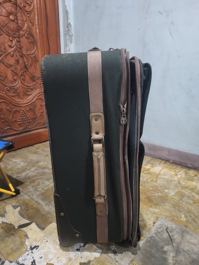 Dark Green Rolling Suitcase with Brown Trim (Category: Luggage) located in Malabon City. Submitted by grfpx (Listing ID 1462552413, Image 3). Description: - Dark green rolling suitcase - Brown trim accents - Two convenient front pockets - Retractable handle for easy maneuvering - Smooth-rolling wheels for effortless transport - Sturdy side handle - Perfect for all your travel needs.