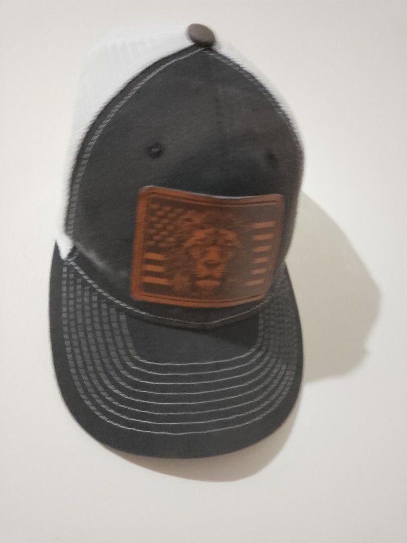 Dark Grey Trucker Hat with Lion Patch (Category: Caps & Hats) located in Cavite. Submitted by rodrycuteshop (Listing ID 1462643704, Image 3). Description: - Stylish trucker hat - Dark grey front panels with white mesh back - Leather patch with lion and American flag design - Detailed stitching on brim - Adjustable snapback closure - Ideal for casual wear - with flaws: white discoloration .