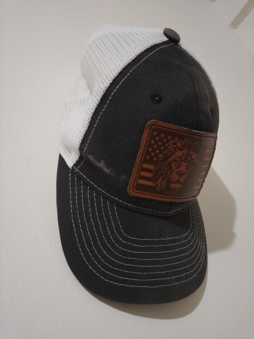 Dark Grey Trucker Hat with Lion Patch (Category: Caps & Hats) located in Cavite. Submitted by rodrycuteshop (Listing ID 1462643704, Image 2). Description: - Stylish trucker hat - Dark grey front panels with white mesh back - Leather patch with lion and American flag design - Detailed stitching on brim - Adjustable snapback closure - Ideal for casual wear - with flaws: white discoloration .