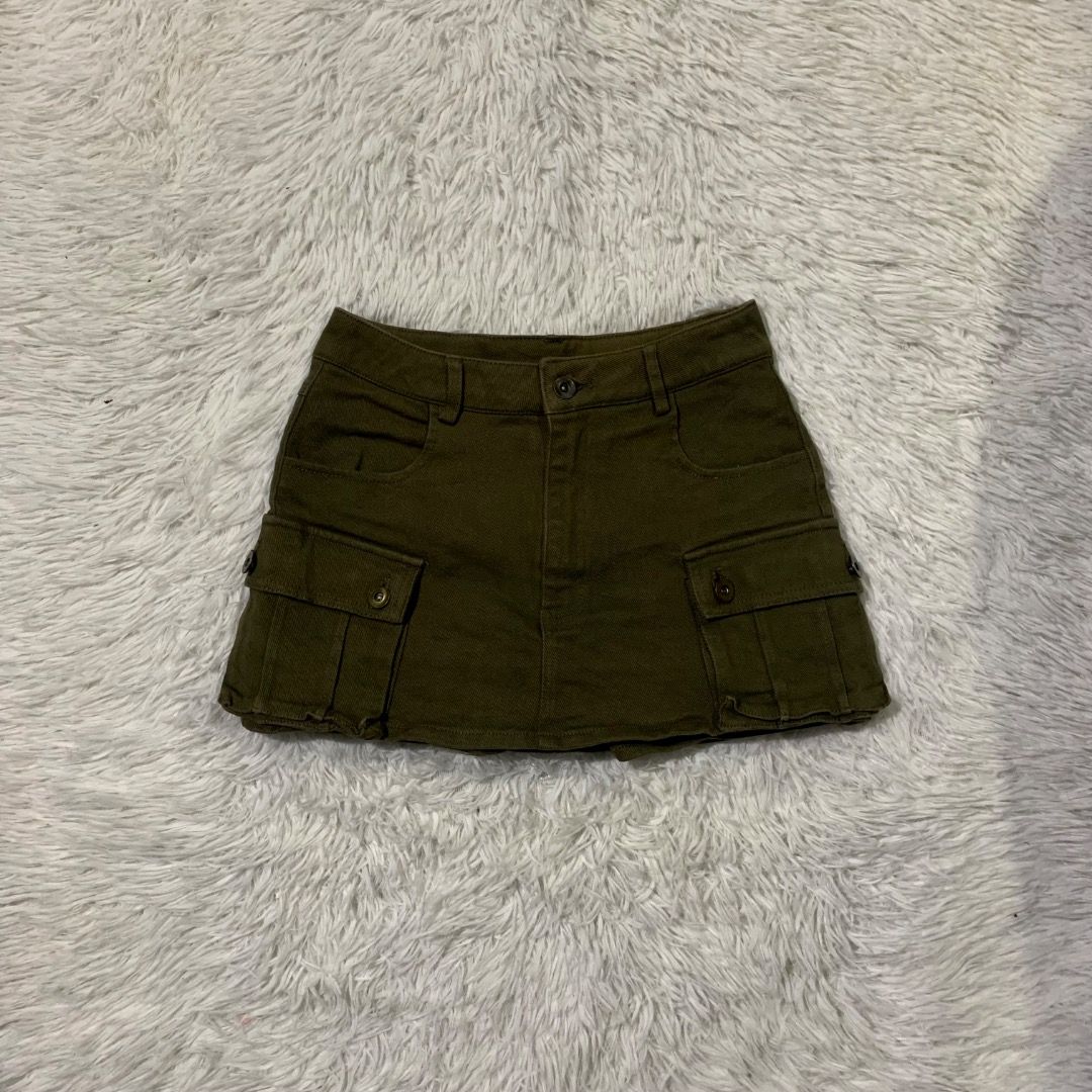 Dark green Cargo Mini Skirt (Category: Skirts) located in Caloocan City. Submitted by emmalizz (Listing ID 1462605929, Image 1). Description: - Dark wash cargo mini skirt - Multiple pockets with button closures - Belt loops - Adjustable side straps - Raw hem detail - Estimated size: Small to Medium - Ideal for a casual streetwear aesthetic.