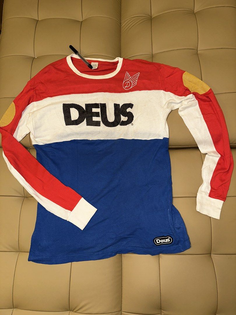 Deus Ex Machina Long Sleeve Mesh Shirt (Category: Tshirts & Polo Shirts ) located in Quezon City. Submitted by mancave_stuff (Listing ID 1462517864, Image 1). Description: - Deus Ex Machina long sleeve shirt - Made with breathable mesh material - Striking red, white, and blue color block design - Features the iconic Deus logo on the front - Smaller Deus logo detail on the sleeve hem - Unique yellow accents on shoulders and elbows - Ideal for casu