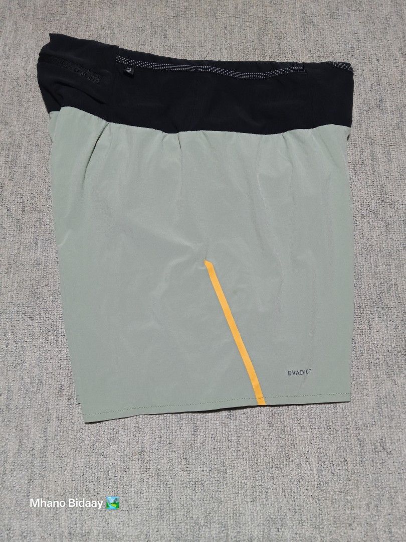 Evadict Men's 2-in-1 Trail Shorts Quick Drying (Category: Shorts) located in Valencia. Submitted by mhano_bidaay_outdoors_218 (Listing ID 1462552943, Image 2). Description: - Evadict Men's Trail Shorts - Waist: 34-36 inches - Length: 16 inches - Leg Opening: 12 inches - Material: Quick-drying fabric - Style: 2-in-1 with built-in briefs - Ideal for: Running and outdoor activities - Color: Light grey with yellow accents.