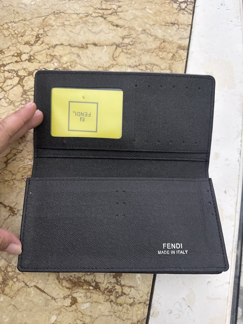 Fendi Zucca Pattern Bi-fold Wallet (Category: Wallets & Card Holders) located in Angeles City. Submitted by migs_font29 (Listing ID 1462530630, Image 3). Description: - Classic Fendi wallet with iconic Zucca pattern - Color: Black leather - Made in Italy - Interior features card slots and a note compartment - Serial number: M60326 stamped inside - Comes with a yellow Fendi card holder.
