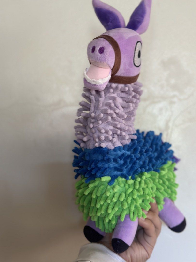 FORTNITE Marlowe The Llama Plush Toy (Category: Plushies & Soft Toys) located in Baguio. Submitted by cherylcaps95 (Listing ID 1462678178, Image 3). Description: - Adorable purple Marlowe the Llama plush toy. - Features fuzzy green, blue, and purple sections. - Comes with a cute brown bridle. - Has big, expressive eyes. - Ideal for llama collectors or as a fun decorative piece. 15” big and very stuffed. .