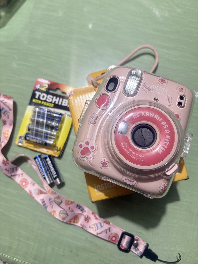 Fujifilm Instax Mini 11 Pink Camera with Accessories (Category: Cameras) located in Las Pinas. Submitted by raretree_4cff17 (Listing ID 1462658878, Image 1). Description: Pink Fujifilm Instax Mini 11 camera with strap, case, and batteries..