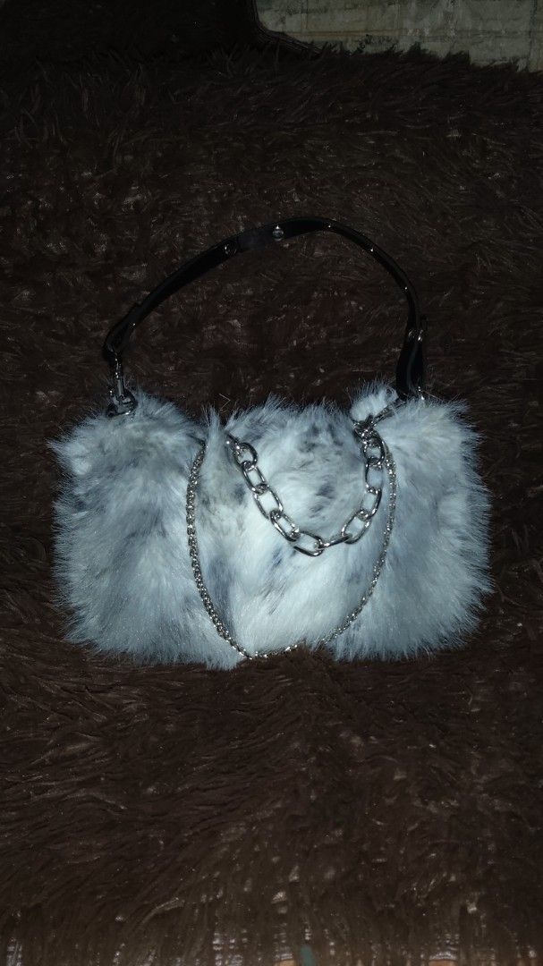 Grey Faux Fur Bag with Chain Strap (Category: Shoulder Bags) located in Lapu Lapu. Submitted by messdup (Listing ID 1462511754, Image 1). Description: - Adorable grey and white faux fur bag - Versatile strap options: silver chain and black faux leather - Secure zipper closure - Lined with dark brown fabric - Ideal for evening events or a fun fashion statement.