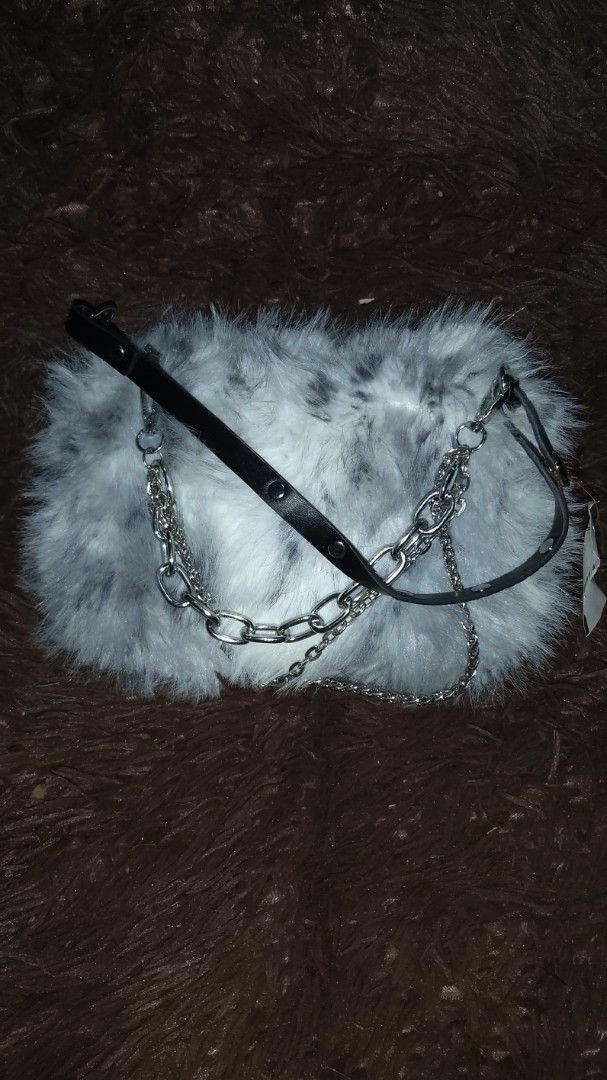 Grey Faux Fur Bag with Chain Strap (Category: Shoulder Bags) located in Lapu Lapu. Submitted by messdup (Listing ID 1462511754, Image 3). Description: - Adorable grey and white faux fur bag - Versatile strap options: silver chain and black faux leather - Secure zipper closure - Lined with dark brown fabric - Ideal for evening events or a fun fashion statement.