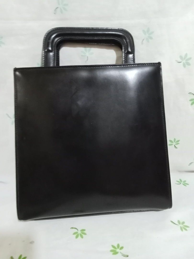 Gucci Black Leather Top Handle Bag (Category: Luxury Bags & Wallets) located in Baguio. Submitted by sheren_signatures (Listing ID 1462623575, Image 2). Description: - Classic black leather Gucci handbag - Square shape with a single top handle - Iconic Gucci logo plate on the front - Interior zippered compartment - Serial number visible inside - Timeless and collectible piece - Flaws in the lining (please check the pic) .