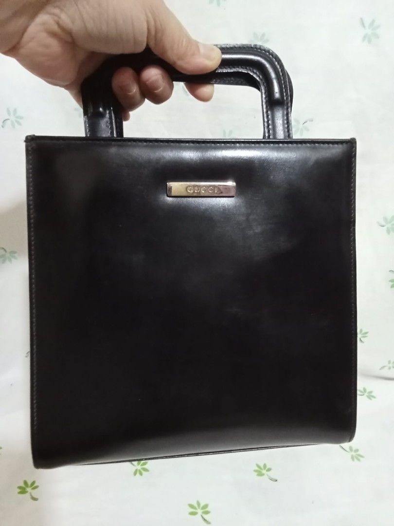 Gucci Black Leather Top Handle Bag (Category: Luxury Bags & Wallets) located in Baguio. Submitted by sheren_signatures (Listing ID 1462623575, Image 1). Description: - Classic black leather Gucci handbag - Square shape with a single top handle - Iconic Gucci logo plate on the front - Interior zippered compartment - Serial number visible inside - Timeless and collectible piece - Flaws in the lining (please check the pic) .