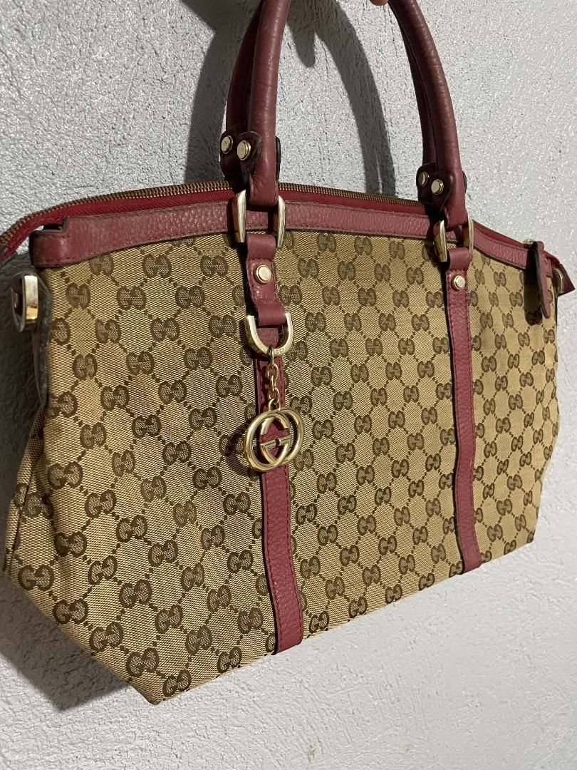 Gucci Monogram Canvas Leather Trimmed Handbag (Category: Luxury Bags & Wallets) located in Manila. Submitted by buyingprelovedukayukay (Listing ID 1462616303, Image 1). Description: - Gucci handbag - Classic GG monogram canvas - Red leather trim - Gold tone hardware - Iconic interlocking G charm - Top zip closure - Comfortable handles for carrying - Great everyday bag.