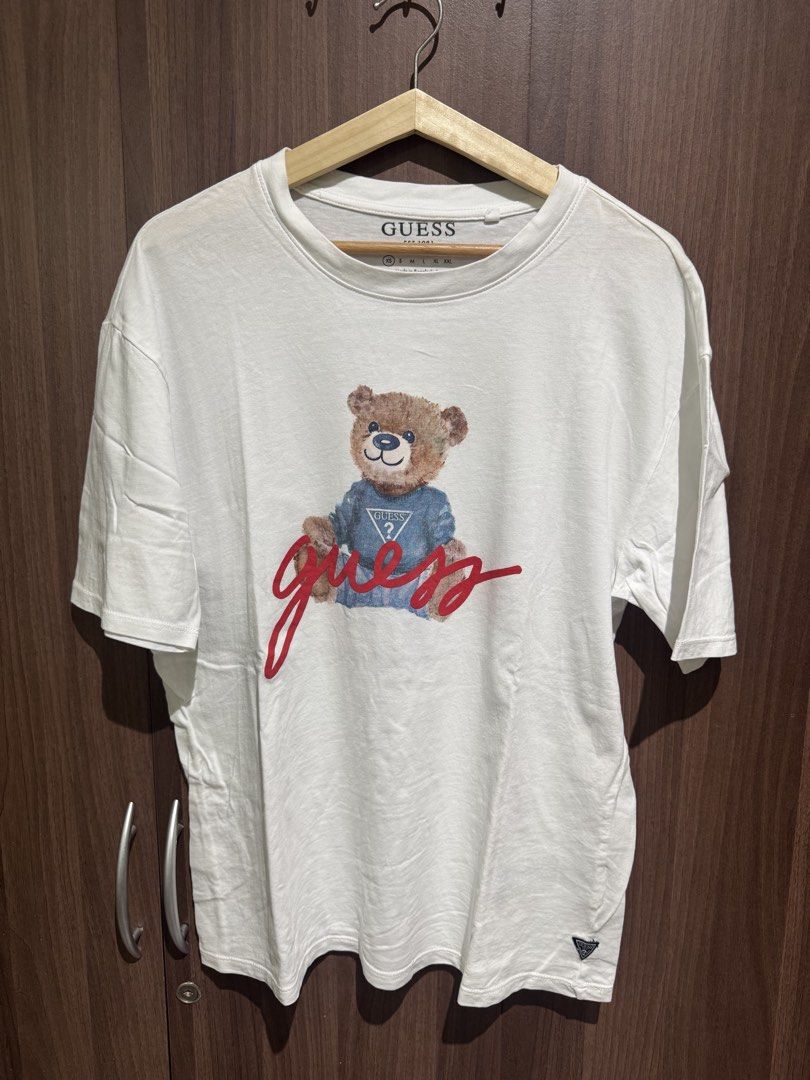 Guess bear white tshirt (unisex) (Category: Tshirts & Polo Shirts ) located in Valenzuela. Submitted by shop.spark.joy (Listing ID 1462584635, Image 1). Description: L- 21 in W- 19 in.