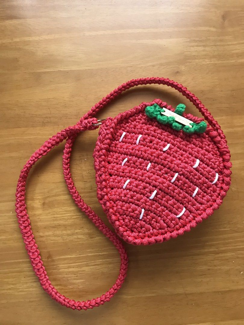 Handmade Strawberry Crocheted Bag with Strap (Category: Shoulder Bags) located in Imus. Submitted by mrsz3r0 (Listing ID 1462506104, Image 3). Description: - Adorable strawberry-shaped bag - Hand-crocheted craftsmanship - Features a braided strap - White stitching mimics strawberry seeds - Cute green leaf detail at the top - Includes a small 'Hook & Yarn St.' wooden tag - Ideal for children or as a playful accessory.