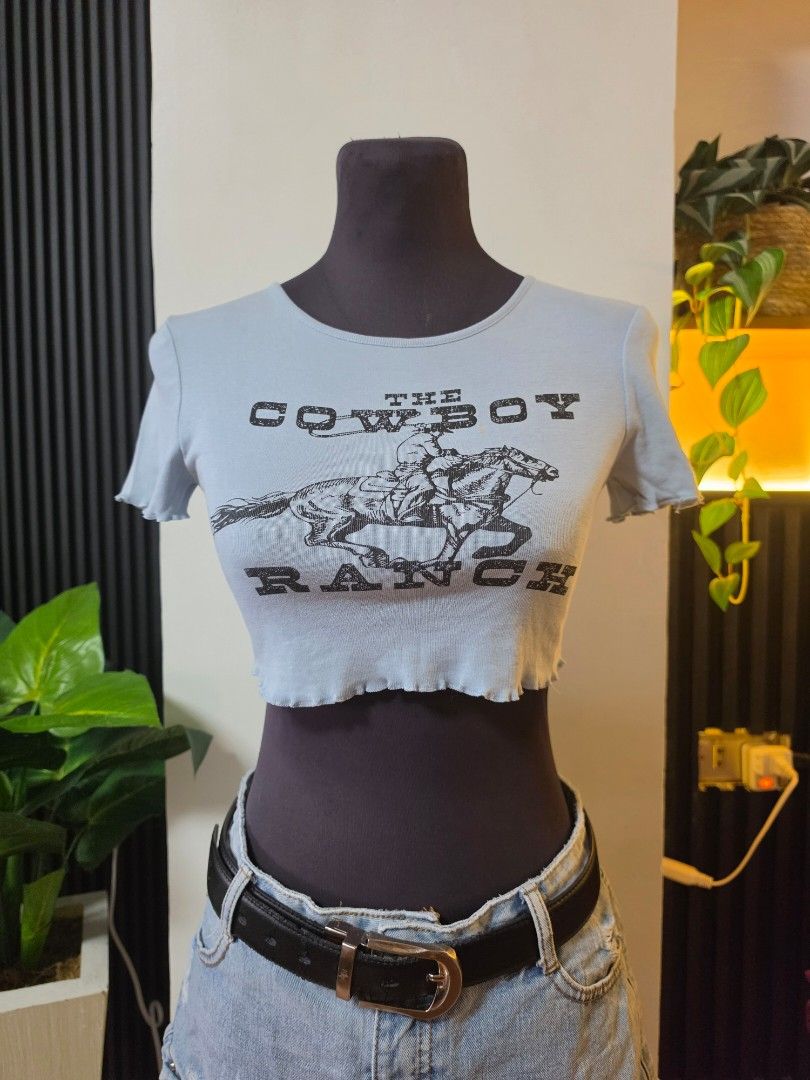 H&M Divided Light Blue Graphic Crop Top xs to small (Category: Others Tops) located in Paranaque City. Submitted by franinnashop (Listing ID 1462511708, Image 1). Description: - Light blue graphic crop top from H&M Divided - Features a 'Come On Cowboy Ranch' graphic with a cowboy on a horse - Raw hem detail for a trendy look - Ideal for casual wear and everyday style declutter xs to small with minimal stain paranaque city.