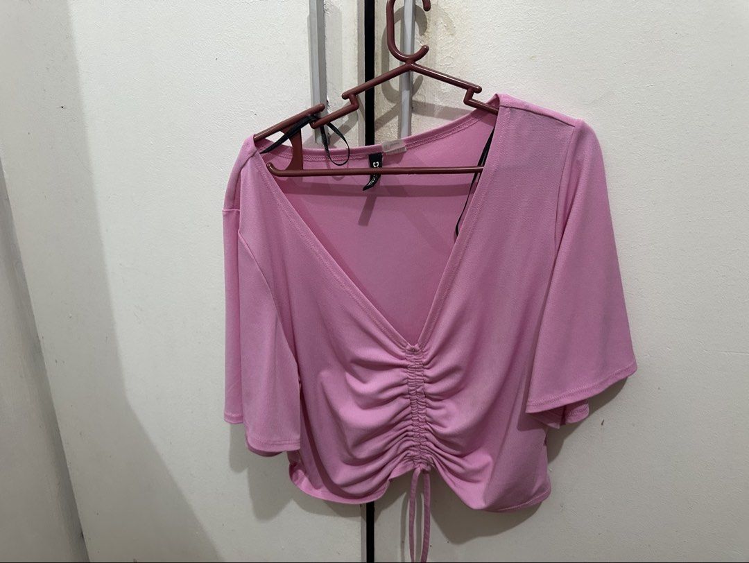 H&M Divided Pink Ruched Drawstring Crop Top (Category: Sleeveless) located in Mandaluyong City. Submitted by gbtnhc (Listing ID 1462458169, Image 2). Description: - Used once only - Features a ruched drawstring detail in the front - V-neckline with short sleeves, flowy material - RFS: doesn’t fit me anymore.