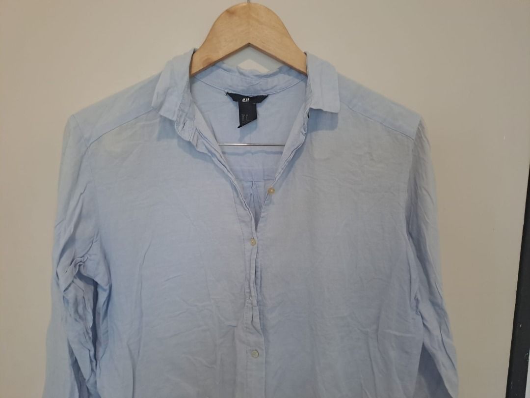 H&M light blue cotton (Category: Longsleeves) located in Mandaluyong City. Submitted by epicowl-c93c (Listing ID 1462584567, Image 2). Description: The image displays a classic light blue long-sleeve button-down shirt from the brand H&M, characterized by its relaxed fit and soft, slightly crinkled casual texture..