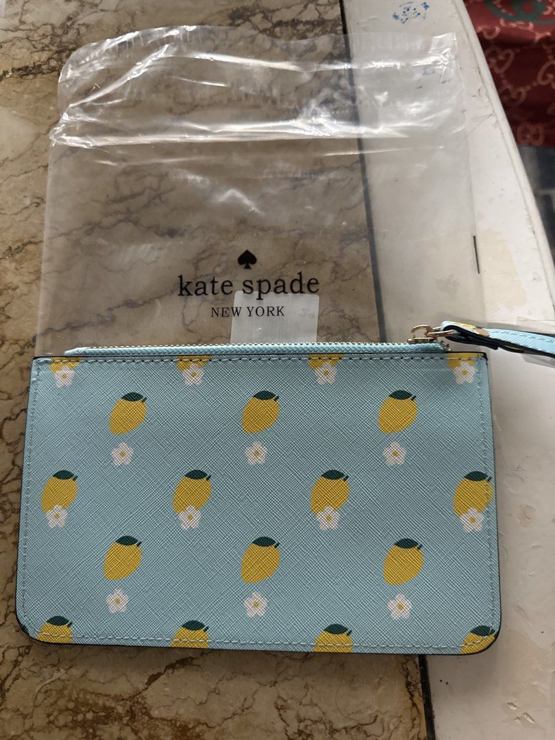 Kate Spade New York Lemon Print Pouch (Category: Community) located in Angeles City. Submitted by migs_font29 (Listing ID 1462512457, Image 2). Description: - Adorable Kate Spade pouch with a vibrant lemon print. - Features a light blue background adorned with yellow lemons and delicate white flowers. - Secure zipper closure for your essentials. - Convenient wrist strap for easy carrying. - Includes original packaging. - Original retail price was