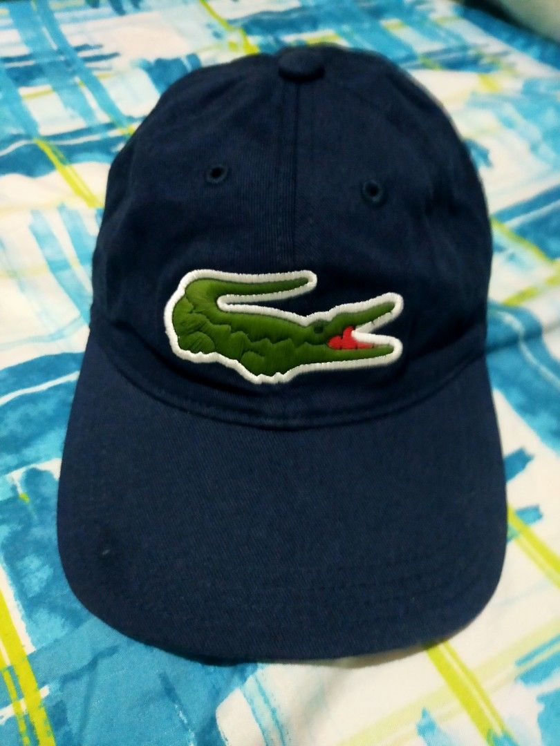 Lacoste Navy Blue Cap with Crocodile Logo (Category: Caps & Hats) located in Makati City. Submitted by lemron18 (Listing ID 1462482497, Image 1). Description: - Classic navy blue Lacoste cap - Features the iconic green crocodile logo on the front - Adjustable strap at the back for a comfortable fit - Made from durable material - Perfect for everyday wear or sports activities.