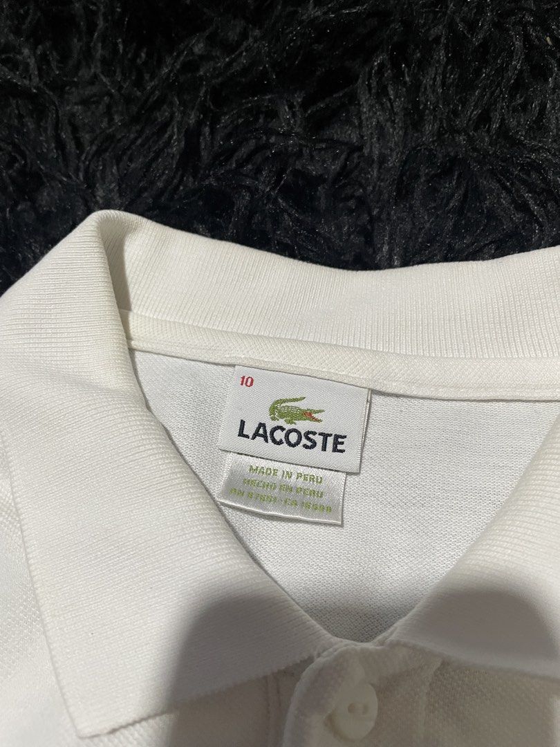 Lacoste White Polo Shirt Size 10 (Category: Tshirts & Polo Shirts ) located in Munoz. Submitted by bb_jimbo0 (Listing ID 1462624969, Image 3). Description: - Classic white Lacoste polo shirt - Iconic crocodile logo on chest - Made in Peru - Size 10 - Versatile for casual or smart-casual outfits - Timeless and simple design.