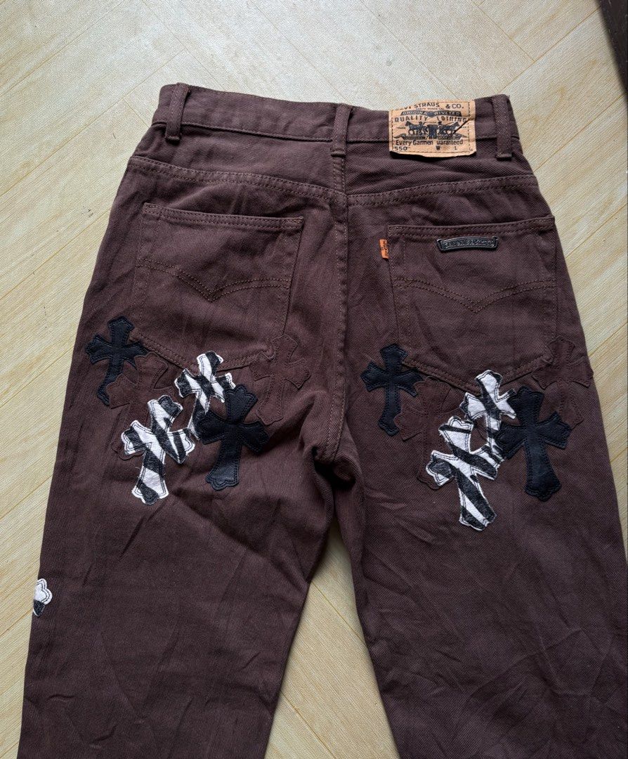 LEVIS x CHROMEHEARTS (Category: Jeans) located in Iligan City. Submitted by seddicmoti2002 (Listing ID 1462459728, Image 2). Description: - Brown denim jeans - Unique cross patches on front and back - Some patches feature zebra print detail - Button and zip fly closure - Classic five-pocket design - Statement piece for a distinctive style.
