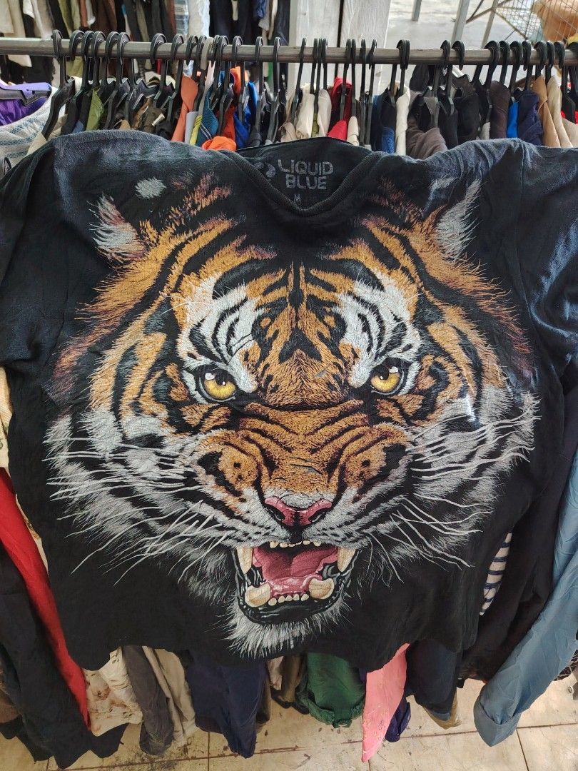 Liquid Blue Tiger Graphic T-Shirt 2016 (Category: Tshirts & Polo Shirts ) located in Manila. Submitted by freeshipping.nationwide (Listing ID 1462631835, Image 1). Description: - Bold black t-shirt featuring a vibrant, detailed tiger graphic. - Brand: Liquid Blue - Copyright: 2016 - Estimated Size: Medium - Ideal for lovers of animal prints and statement tees..