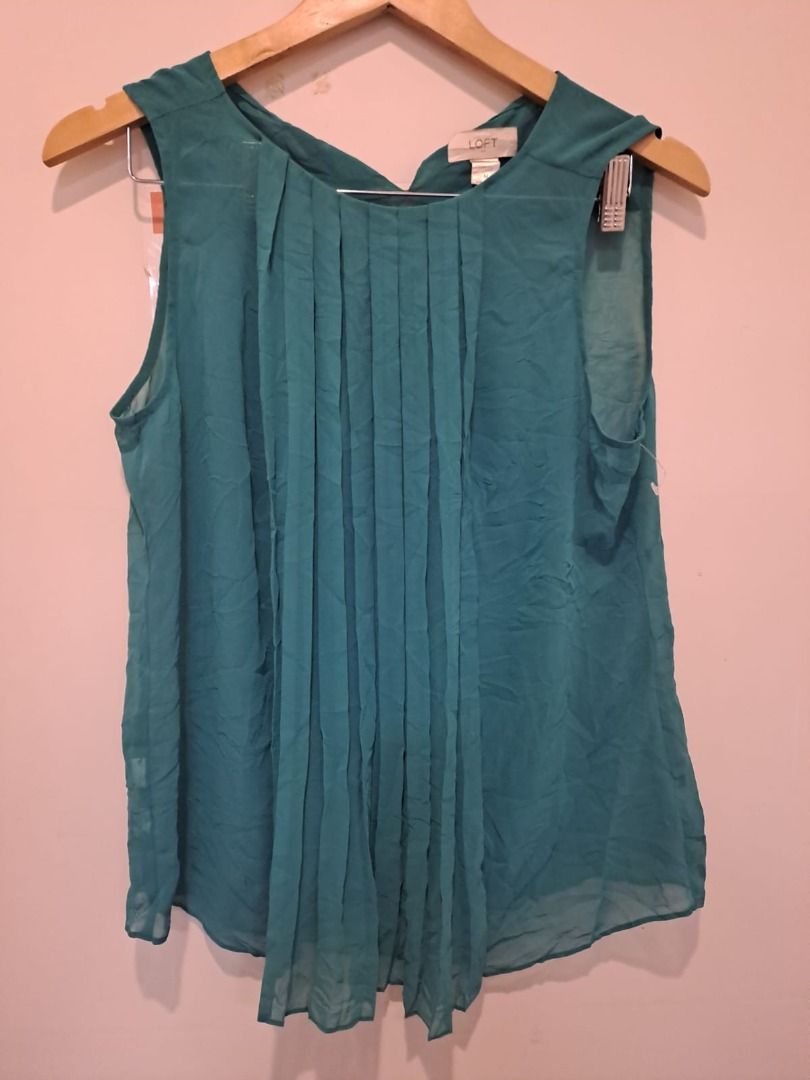 Loft by anne taylor olive green (Category: Sleeveless) located in Mandaluyong City. Submitted by epicowl-c93c (Listing ID 1462585793, Image 1). Description: This is a teal pleated sleeveless blouse from the popular retail brand LOFT (originally a division of Ann Taylor).The garment features a crew neckline with structured vertical accordion pleats flowing down the front bodice. It is made of a lightweight, flowy fabric—typically a polyester or ra