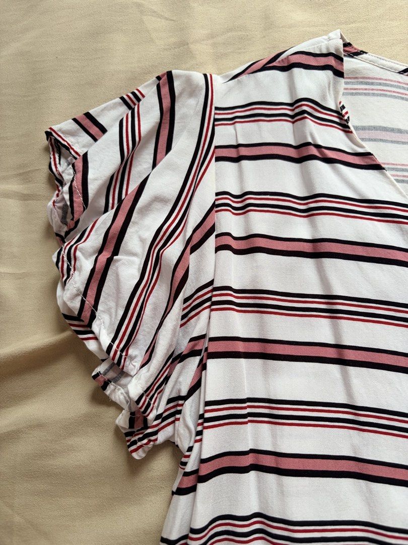 Love Crissa Striped Button-Up Tie-Front Top Size M (Category: Blouses) located in Tabaco. Submitted by shae_3 (Listing ID 1462495692, Image 2). Description: - Brand: Love Crissa - Style: V-neck, button-up front striped top - Sleeves: Short flutter sleeves - Hem: Tied knot detail at the front - Color: Pink, black, and red stripes on a white background - Size: Medium (M).