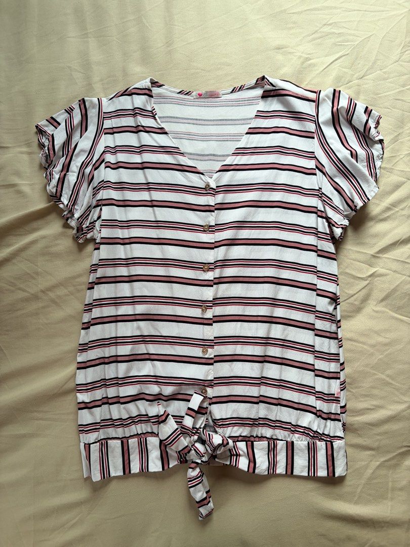 Love Crissa Striped Button-Up Tie-Front Top Size M (Category: Blouses) located in Tabaco. Submitted by shae_3 (Listing ID 1462495692, Image 1). Description: - Brand: Love Crissa - Style: V-neck, button-up front striped top - Sleeves: Short flutter sleeves - Hem: Tied knot detail at the front - Color: Pink, black, and red stripes on a white background - Size: Medium (M).