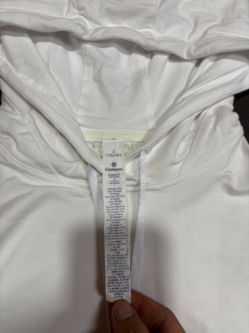 Lululemon White Cotton Blend Hoodie Size 2 (Category: Coats, Jackets and Outerwear) located in Mabalacat. Submitted by _limitlessfashion (Listing ID 1462460312, Image 3). Description: - White Lululemon hoodie - length 21 - width 17 - Comfortable cotton and elastane blend - Adjustable drawstring hood - Elasticated cuffs and hem for a snug fit - Convenient side zippered pocket with Lululemon logo zipper pull - Versatile for workouts or casual every