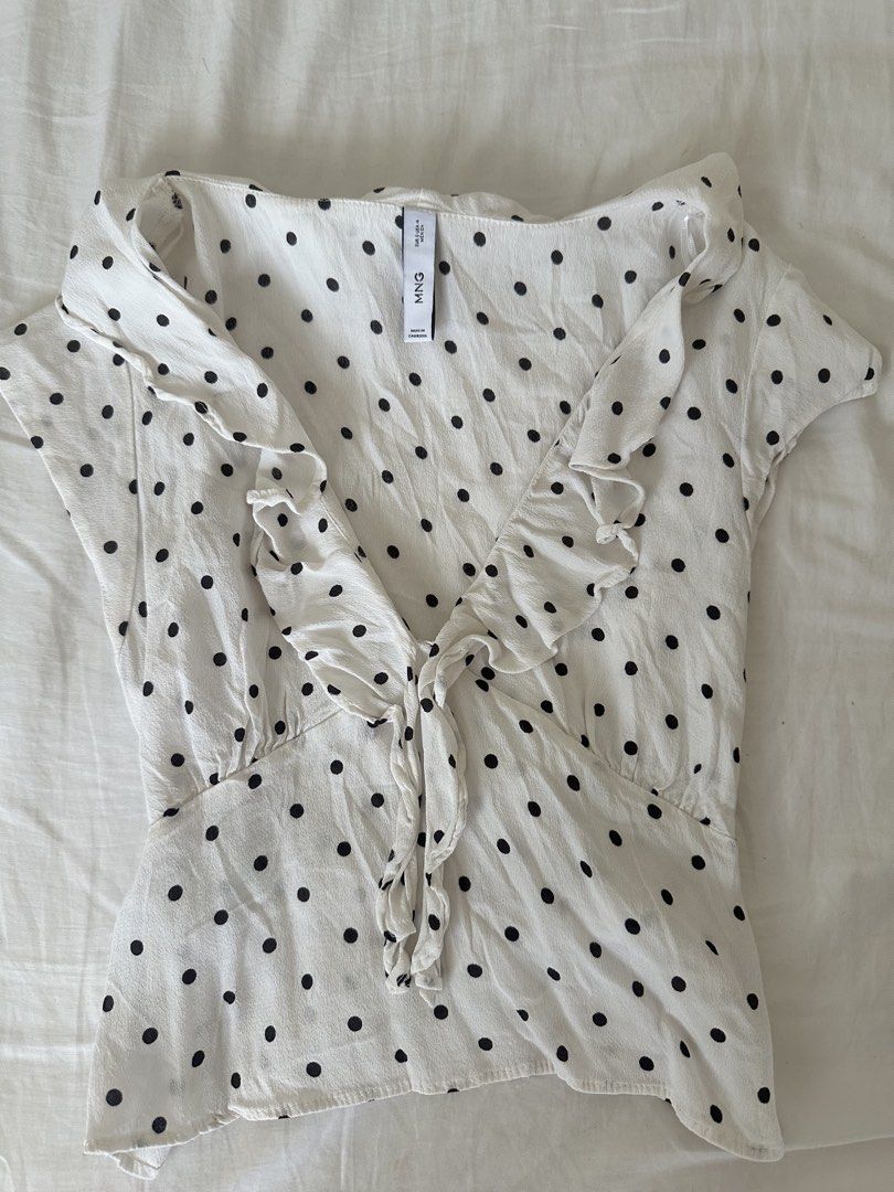 Mango White Black Polka Dot Ruffle Tie Front Top (Category: Blouses) located in Taguig. Submitted by beatrizangela (Listing ID 1462495522, Image 1). Description: - Cute white top with black polka dots - Features a ruffled neckline - Tie front detail - Short sleeves - Can be tied at the waist or worn loose - Easy to style for casual or dressy occasions.